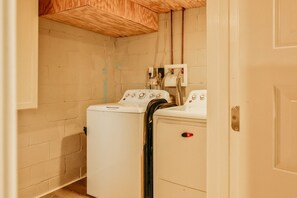 A laundry room with two stacked washers and dryers, wooden ceiling, and a white door. - Essex Smart Stay - Torner Road (Essex)