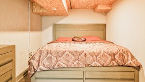 A bedroom with a wooden headboard, a patterned bedspread, and a single pillow. - Essex Smart Stay - Torner Road (Essex)