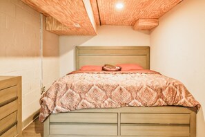 A bedroom with a wooden headboard, a patterned bedspread, and a single pillow. - Essex Smart Stay - Torner Road (Essex)