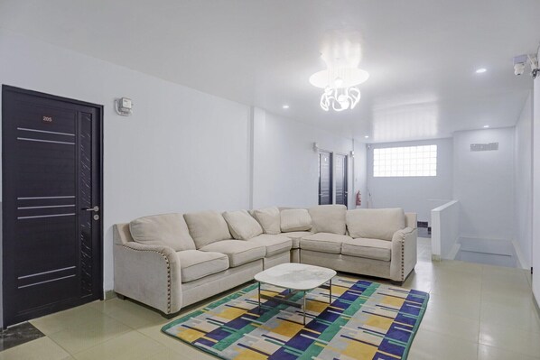 A living room with a beige sectional sofa, a coffee table, and a patterned rug.