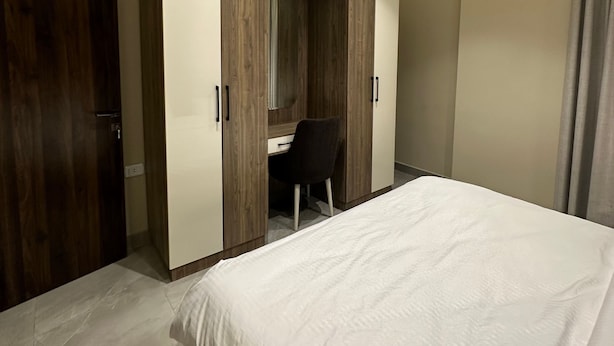 A bedroom with a bed, a desk, and a wardrobe. - 304 Al-najeh JRE Apartments For Rent ave (Amman)