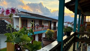Un balcon agrémenté de plantes en pot et offrant une vue sur une chaîne de montagnes.
