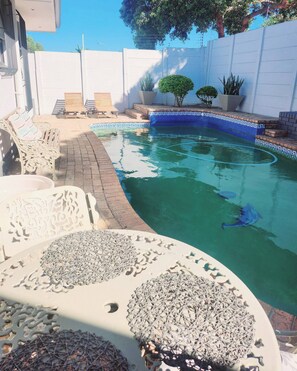A swimming pool with a blue mosaic border, surrounded by a white wall and potted plants. - Bonita Vista Plattekloof (Cape Town)