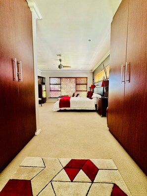 Habitación de hotel con cama, armario y ventilador de techo.