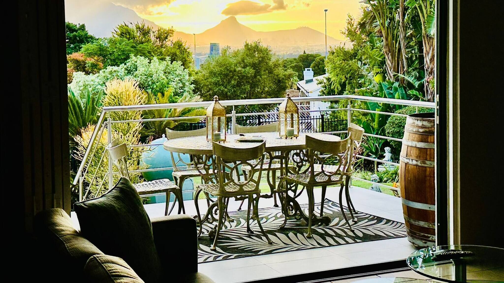 Ein Balkon mit Tisch und Stühlen, Blick auf eine Stadtansicht und ein Berg im Hintergrund.