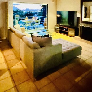 Una sala de estar con un sofá, una mesa de vidrio y un televisor.