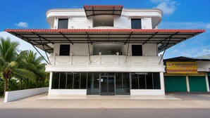A two-story building with a flat roof and a covered entrance. - Haruasa Residence • Cozy Double (Batam)