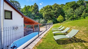 A swimming pool with a covered area, a grassy lawn, and lounge chairs. - Greenwood Retreat With Hot Tub & Sauna (Sveti Martin na Muri)