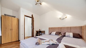 A bedroom with two beds, wooden wardrobe, and a desk with a chair. - Greenwood Retreat With Hot Tub & Sauna (Sveti Martin na Muri)