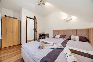 A bedroom with two beds, wooden wardrobe, and a desk with a chair. - Greenwood Retreat With Hot Tub & Sauna (Sveti Martin na Muri)