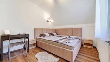 Un dormitorio con una cama, un escritorio y una mesita de noche.