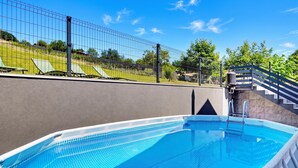 A swimming pool with a clear blue water surface, surrounded by a fence, and a staircase leading to a higher level. - Greenwood Retreat With Hot Tub & Sauna (Sveti Martin na Muri)