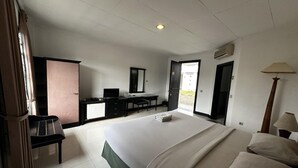 A bedroom with a bed, a desk, a chair, a wardrobe, and a lamp. - Casa D'Ladera Bandung Deluxe Double Stay (Bandung)