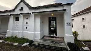 A two-story building with a white facade, black trim, and a tiled roof. - Casa D'Ladera Bandung Standard Double (Bandung)