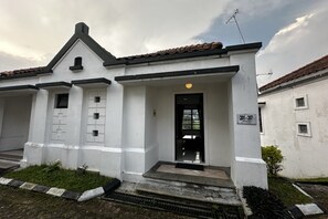 A two-story building with a white facade, black trim, and a tiled roof. - Casa D'Ladera Bandung Standard Double (Bandung)