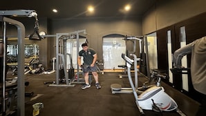 A gym with various exercise equipment, including a squat rack and a bench press. - Casa D'Ladera Bandung Standard Double (Bandung)