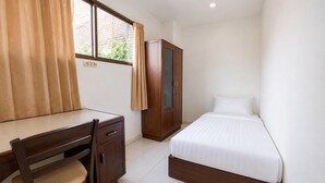 Ein Schlafzimmer mit einem Bett, einem Schreibtisch, einem Stuhl und einem Kleiderschrank.