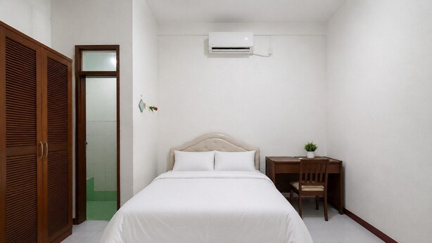 Une chambre à coucher comprenant un lit, un bureau et un appareil de climatisation.