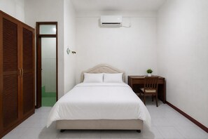 Ein Schlafzimmer mit einem Bett, einem Schreibtisch und einer Klimaanlage.