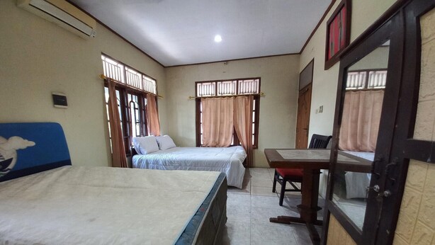Una habitación con dos camas, una mesa y una puerta.
