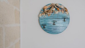 A wall-mounted object with a rustic design, featuring a blue wooden surface and metal hooks.