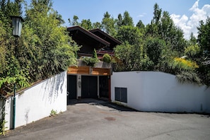 Ein Gebäude mit Holzfassade, einer Garage und einer weißen Wand mit einer Metalttür.