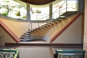 A staircase with a curved design leading to an upper level, surrounded by walls with a tiled floor. - Apartment in Verbania near Lake and Islands (Verbania)