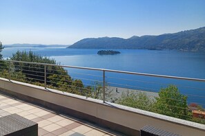 A balcony with a view of a calm lake and distant mountains. - Apartment in Verbania near Lake and Islands (Verbania)