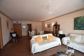 A hotel room with a bed, two bedside tables, a desk, a chair, and a sofa. - Apartment in Verbania near Lake and Islands (Verbania)