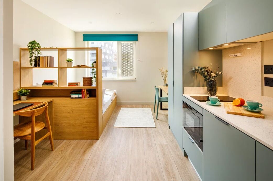 A compact kitchen with a dining area, a small seating space, and a window with a view.