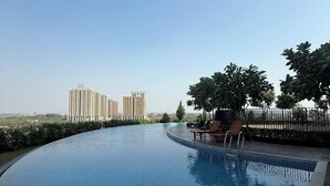 A swimming pool with a view of high-rise buildings in the background. - Modern Japanese Suite with Fast WiFi, Pool and Gym near Meikarta (Cikarang Selatan  (West Java))