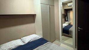 Een hotelkamer met een bed, een kledingkast en een airconditioning.