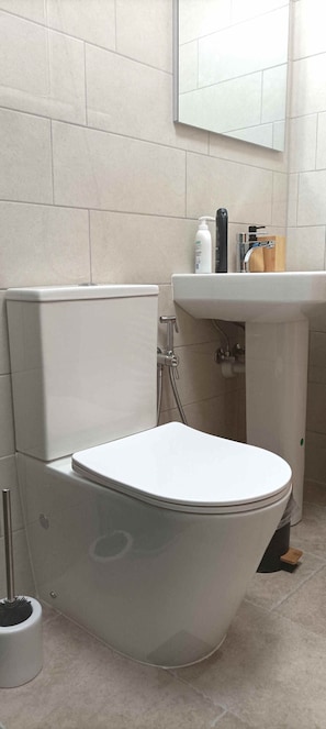 Ein Badezimmer mit Toilette, Waschbecken und Dusche.