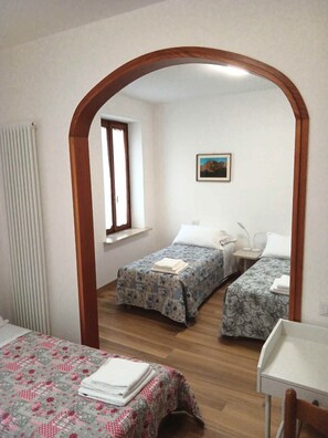 A room with two beds, a small table, and a window. - The perfect base for enchanting hikes in the Dolomites and the famous Pedavena Brewery (Pedavena)