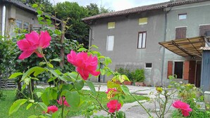 Um edifício residencial com um jardim cheio de flores cor-de-rosa.