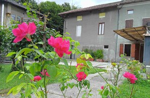 Ein Wohngebäude mit Garten und rosa Blüten.
