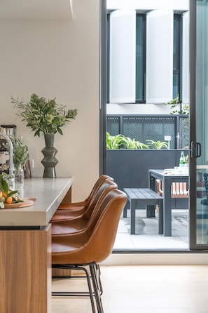 Eine moderne Küche mit Essbereich, großem Fenster und Blick ins Freie.
