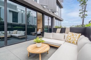 Ein moderner Außenbereich mit einer Sitzecke, einem runden Holztisch und einem Blumentopf.