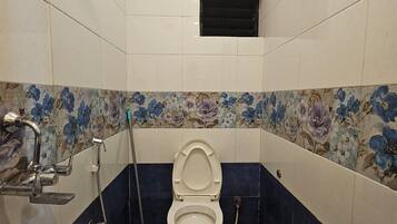 Un baño con inodoro, ducha y bidé.