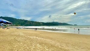 Una playa con sombrillas, una orilla arenosa y vista al mar.