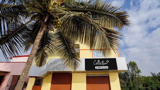 A building with a sign reading 'Collection OYO-Service' and a palm tree in front. - Collection O Shivakote Grama Panchayat (Bangalore)