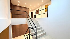 A staircase with a modern design, featuring a black metal railing and wooden paneling on the walls. - Superior Room Patong Beachfront (Tambon Patong)