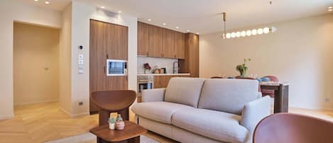 Un salon moderne comprenant un canapé, une table basse et un coin repas avec une table et des chaises.