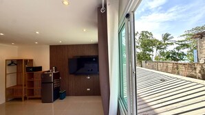 Een modern interieur met een flatscreen televisie, houten planken en een balkon met uitzicht op de omgeving.