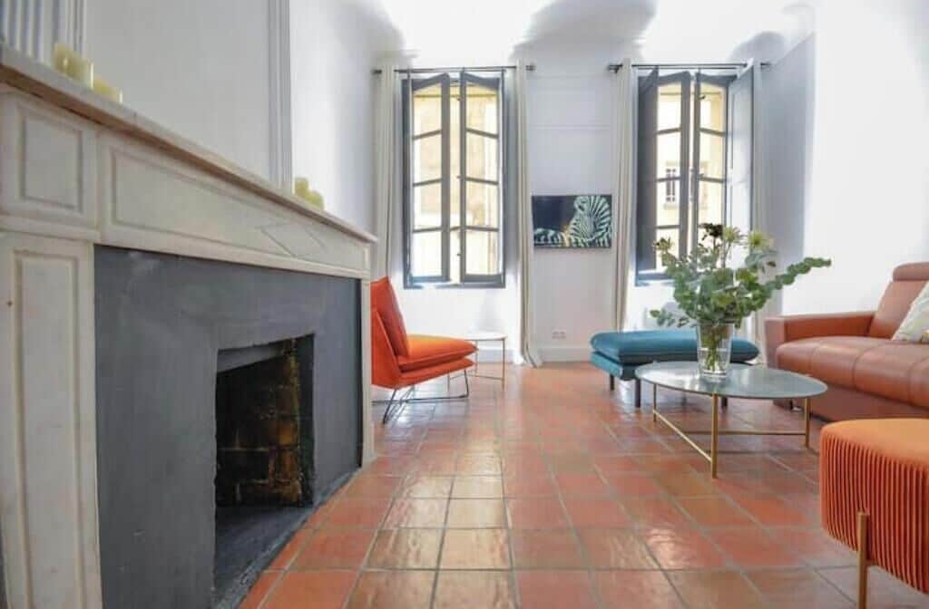 A living room with a fireplace, two windows, a sofa, and a coffee table.