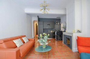 Een woonkamer met een bank, een salontafel en een open haard.