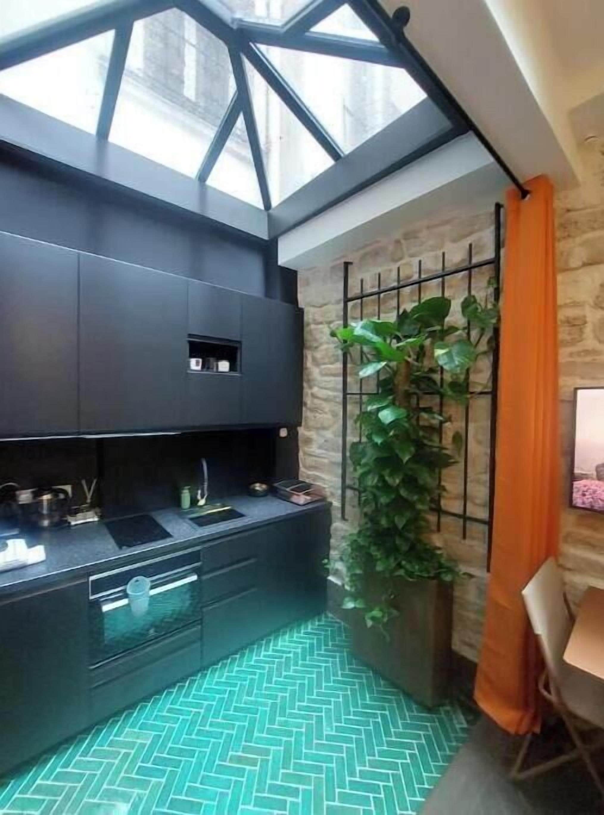 A modern kitchen with a built-in stove, a sink, and a window above the counter.
