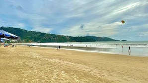 A beach with umbrellas, a sandy shore, and a view of the sea. - Deluxe Beachfront Room, Balcony & Sea View (Tambon Patong)