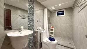 A bathroom with a large sink, toilet, and shower area. - Deluxe Beachfront Room, Balcony & Sea View (Tambon Patong)