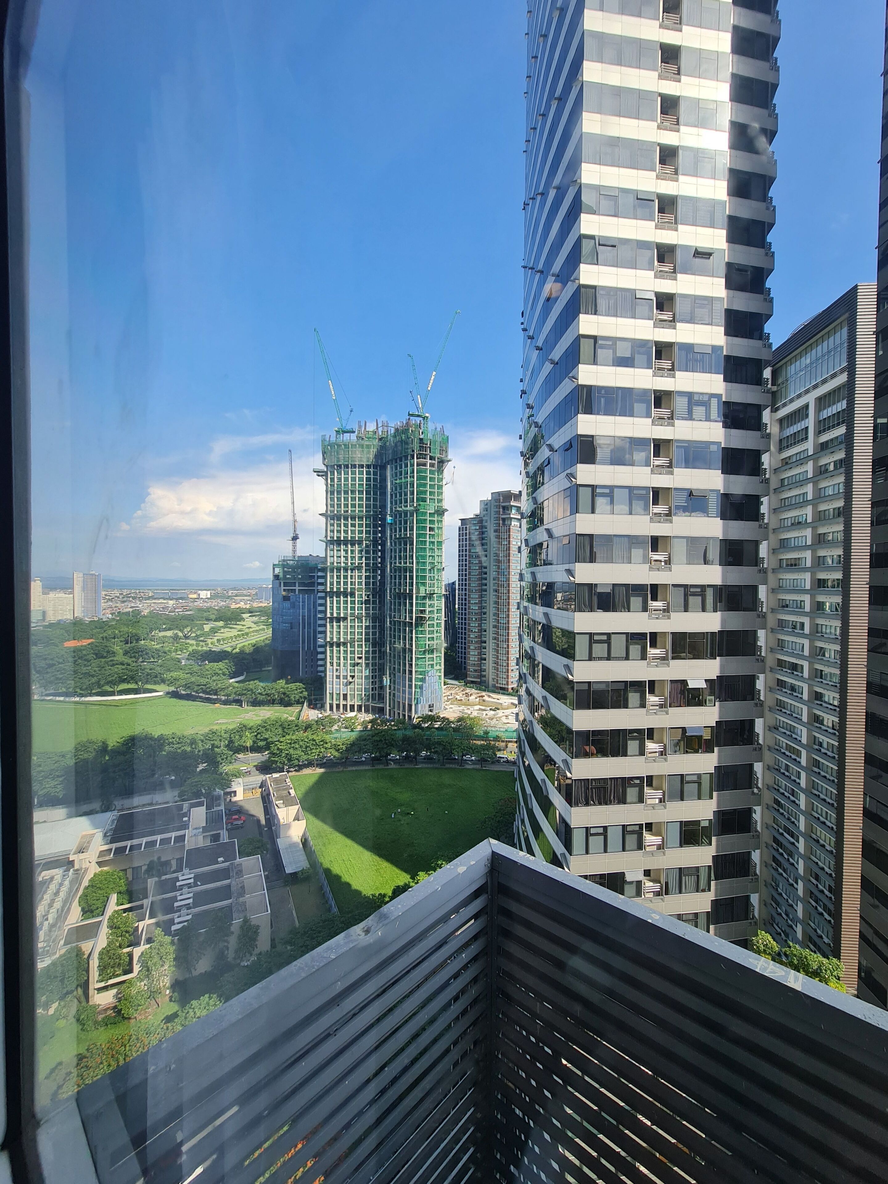 A high-rise building with a modern design, featuring multiple balconies and large windows.